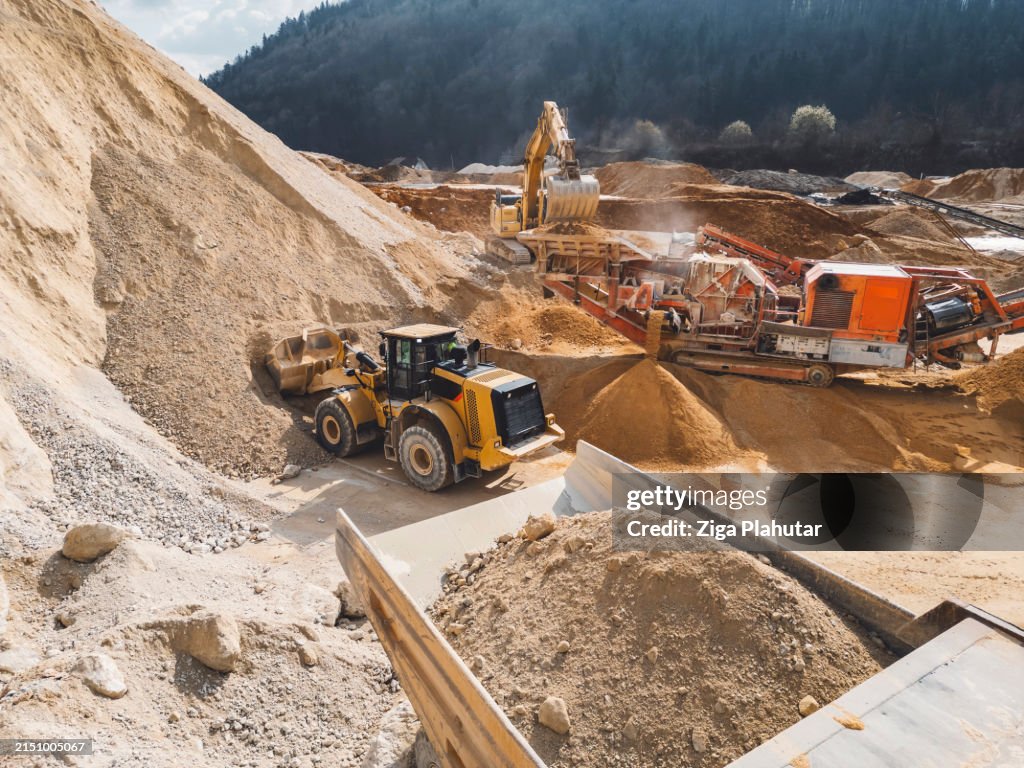 Aerial photo of excavator loading gravel onto a dump truck - Quarry