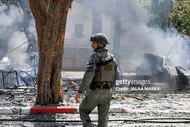 Security forces and emergency personnel deploy at a site hit by rockets fired from southern Lebanon in the northern Israeli city of Kiryat Shmona...