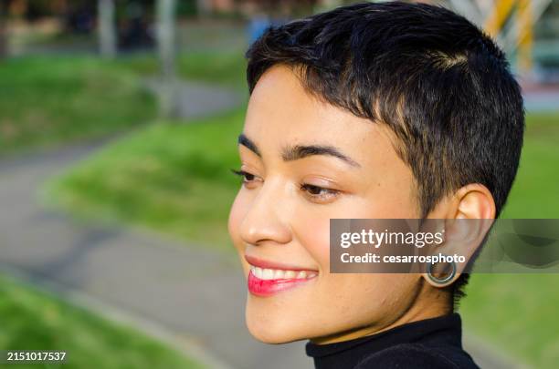 close-up portrait of beautiful happy and confident young woman with short hair wearing casual clothes and stretched ear lobes outdoors in the city - earlobes stock pictures, royalty-free photos & images