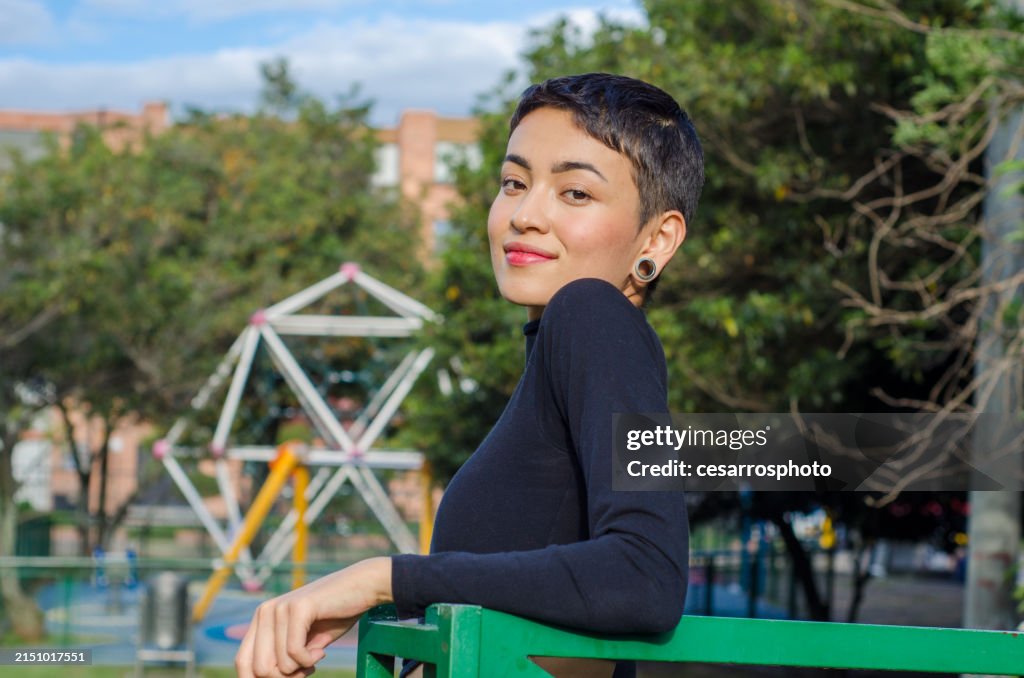 Portrait of beautiful happy and confident young woman with short hair wearing casual clothes and Stretched ear lobes outdoors in the city