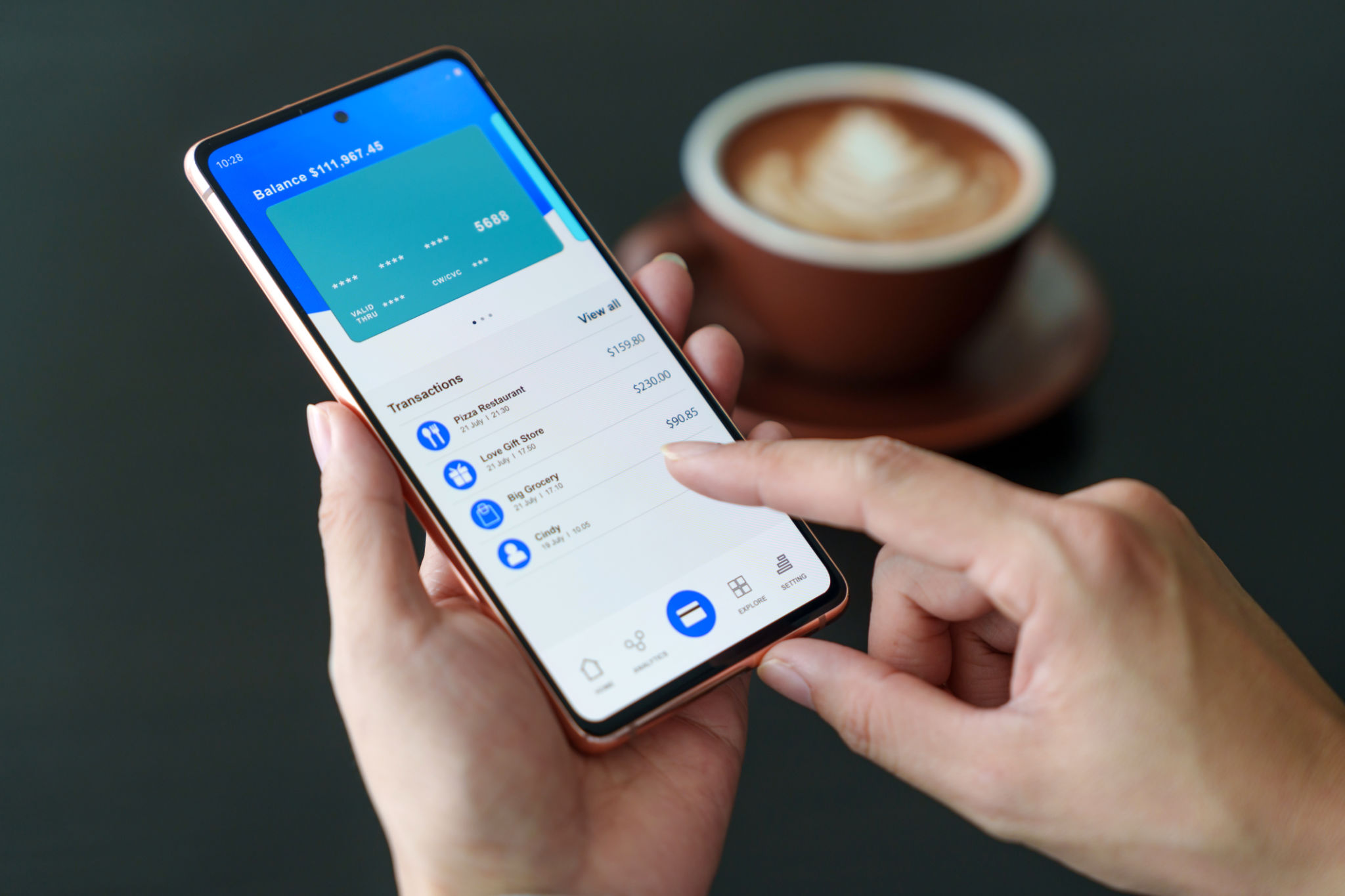 A cropped image of a woman checking her bank account and spending using her mobile device while having a cup of coffee in a cafe. A cropped image of a woman checking her bank account and spending using her mobile device while having a cup of coffee in a cafe.