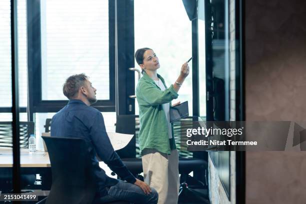 improve team performance and management to make operations more efficient in your business. a product and business development manager is on a business performance review meeting with her team to track and set goals for improvement in a business office. - flexible screen stock pictures, royalty-free photos & images