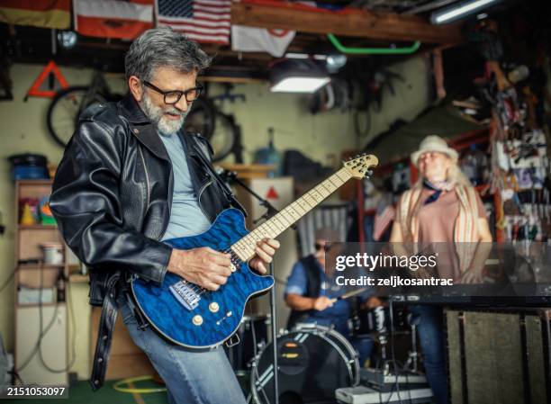 senior friends playing music in the garage reminiscing about the past - rock group stock pictures, royalty-free photos & images