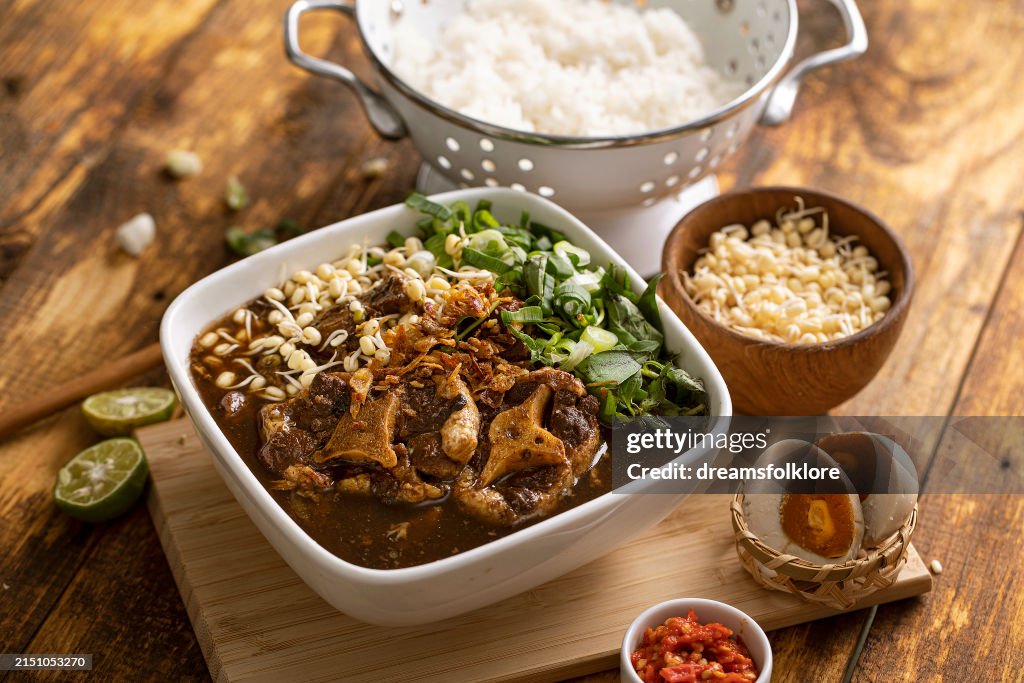 Rawon or black beef soup , a soup with dark broth and savory taste, served with salted egg and rice