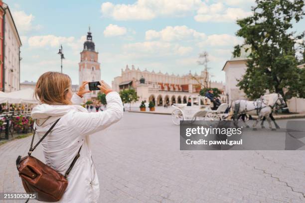 woman visiting rynek glowny square old town krakow with cloth hall poland - rynek square stock pictures, royalty-free photos & images