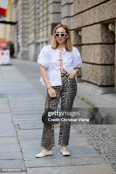 Sonia Lyson is seen wearing Ballerinas Zara, leopard print pants & white blouse Ganni, bag & sunglasses Dior, belt Hermes on May 01, 2024 in Berlin,...