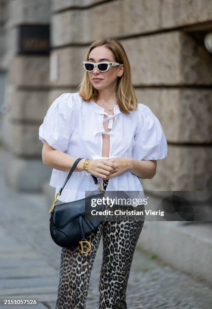 Sonia Lyson is seen wearing leopard print pants & white blouse Ganni, bag & sunglasses Dior, belt Hermes on May 01, 2024 in Berlin, Germany.