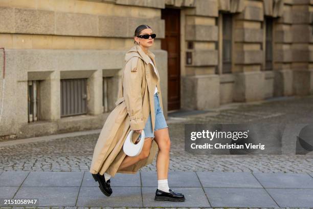 Sophia Geiss is seen wearing denim shorts Levi’s , beige trenchcoat Cos, loafers LeGer by Lena Gercke, white socks, white bag Coperni, Tshirt Uniqlo,...