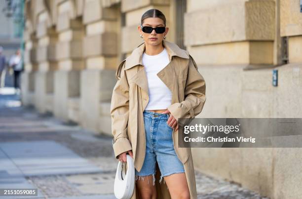 Sophia Geiss is seen wearing denim shorts Levi’s , beige trenchcoat Cos, white bag Coperni, Tshirt Uniqlo, sunglasses Prada on May 01, 2024 in...