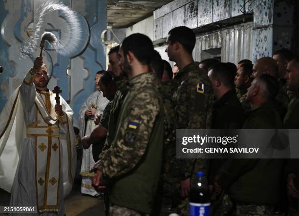 Chaplain blesses traditional cakes and eggs for servicemen of the 24th brigade of Ukrainian Army during the Easter service in an undisclosed location...