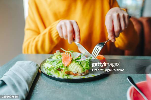 overeating and food addiction. woman having breakfast in a cafe - zalm gerecht stockfoto's en -beelden