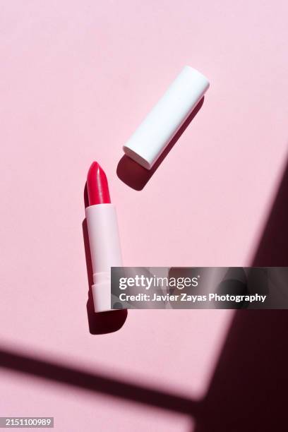 red lipstick isolated on pink background - rode lippenstift stockfoto's en -beelden