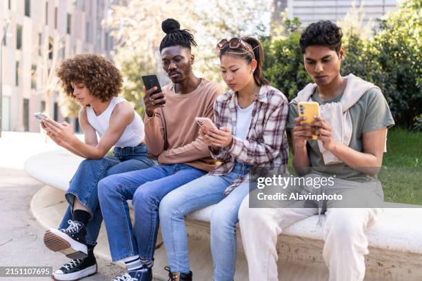 group of friends engrossed in smartphones outdoors - ignoring stock pictures, royalty-free photos & images