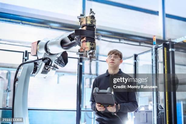 engineer programming robot on cnc machine in engineering factory - it apprentice stock pictures, royalty-free photos & images