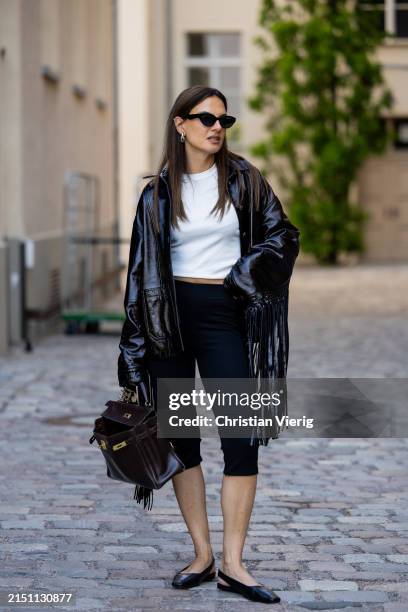 Anna Winter is seen wearing black capri cropped trouser &other stories, white Tshirt ASOS, shoes Vagabond, black bag Hermes, black fringed jacket...