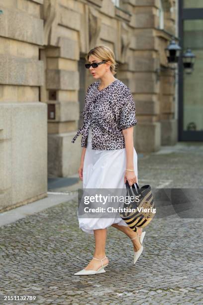 Victoria Scheu is seen wearing white skirt Zara, elephant bag Loewe, sunglasses Kaleos, white heels, leopard print top on May 02, 2024 in Berlin,...
