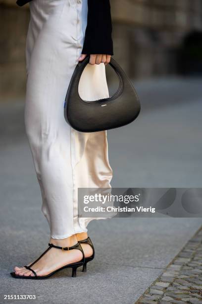 Bella Emar is seen wearing Tezenis Knitted black sweater, Na-kd satin skirt, black Coperni bag, Massimo Dutti heels on May 02, 2024 in Berlin,...