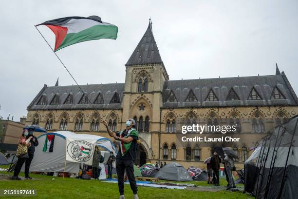 Student activist waves a Palestinian flag at a pro-Palestine encampment at Oxford University on May 6, 2024 in Oxford, England. The appearance of the...