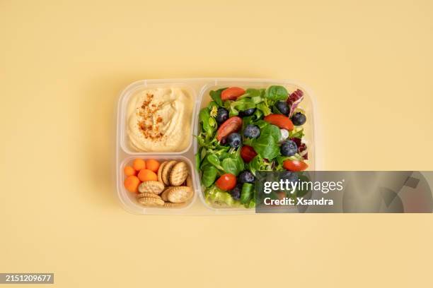 lunchbox mit salat und hummus auf gelbem hintergrund - salatschüssel stock-fotos und bilder