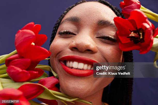 smiling teenage girl with fresh red tulip flowers - pintalabios rojo fotografías e imágenes de stock