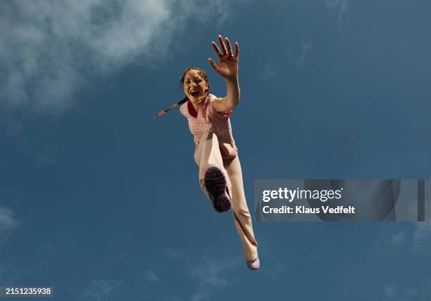 happy young woman jumping high up with arm outstretched - levitazione foto e immagini stock