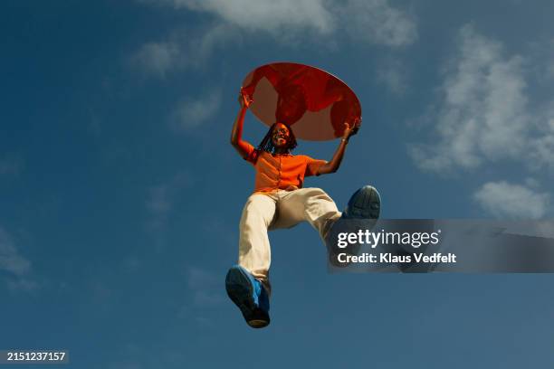 happy young man with red glass levitating mid-air - blue shoe stock pictures, royalty-free photos & images