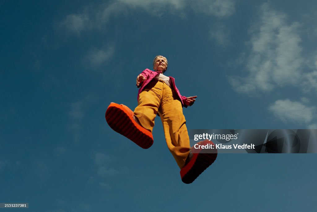 Confident senior woman levitating mid-air