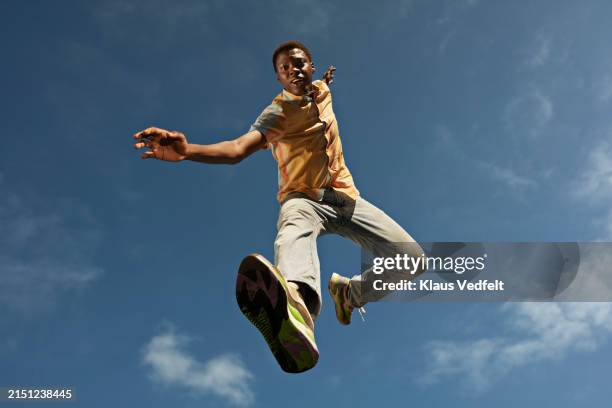 young man dancing while jumping mid-air - lévitation photos et images de collection