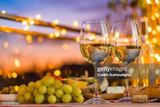 two white wine glasses on outdoors restaurant table - witte wijn stockfoto's en -beelden