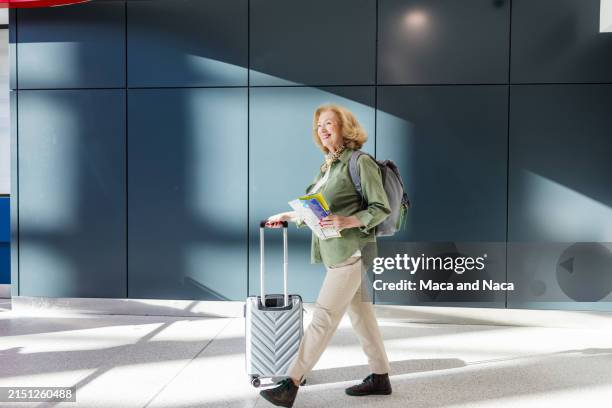 senior woman traveling solo - rullväska bildbanksfoton och bilder