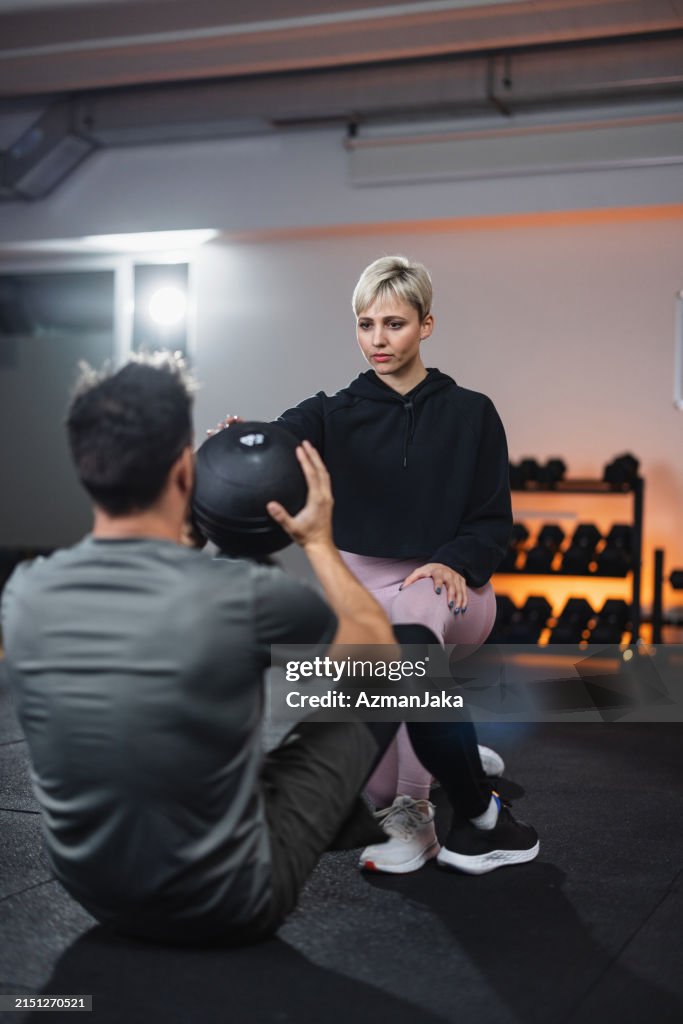 Coach With Client Fitness Coach Assisting Male Client With Exercise High-Res Stock Photo ...