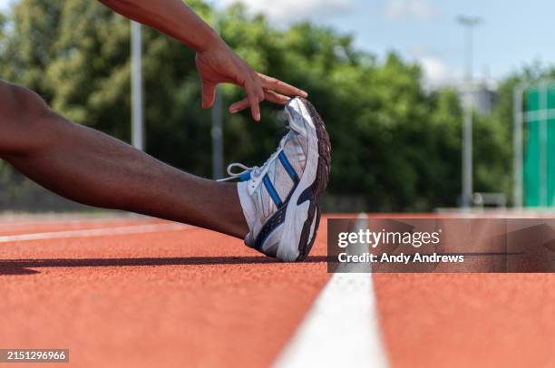 runner stretching on running track - stretch hamstrings stock pictures, royalty-free photos & images