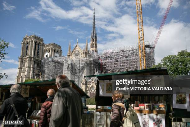 Bouquiniste stand with the view of the Notre Dame Cathedral in Paris, France on May 3, 2024. The reconstruction, which aims to be ready before the...