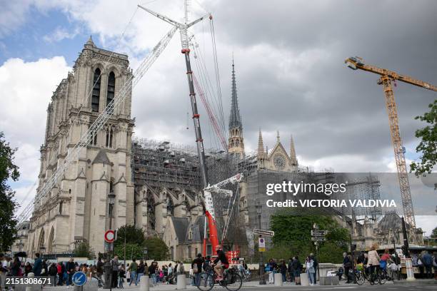 Tourists stroll in front of the Notre Dame Cathedral in Paris, France on May 3, 2024. The reconstruction, which aims to be ready before the Olympic...