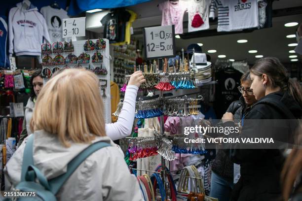 Tourists buying souvenirs of Paris by the side of the Notre Dame Cathedral in Paris, France on May 3, 2024. The reconstruction, which aims to be...