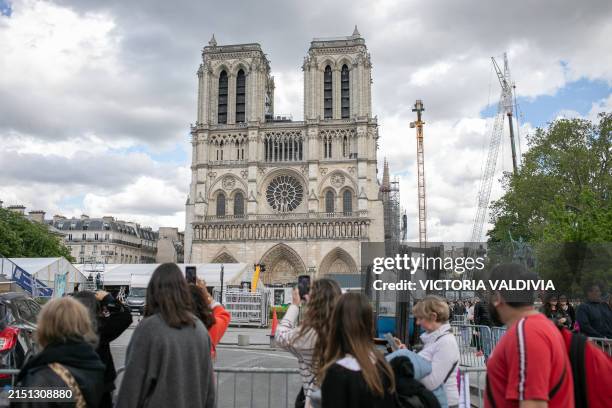 Tourists looking at the Notre Dame Cathedral in Paris, France on May 3, 2024. The reconstruction, which aims to be ready before the Olympic Games, is...