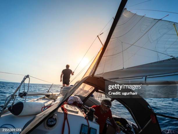 sailor watching the environment on a sailboat. - rudder stock pictures, royalty-free photos & images