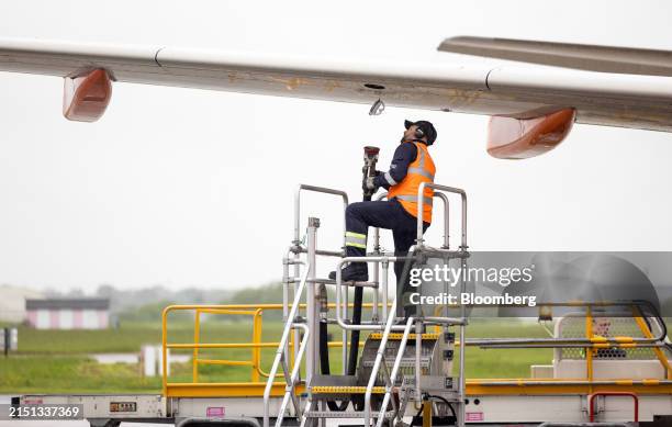 An employee prepares to attach a refuelling hose to an EasyJet Plc passenger aircraft at London Southend Airport in Southend-on-Sea, UK, on Friday,...