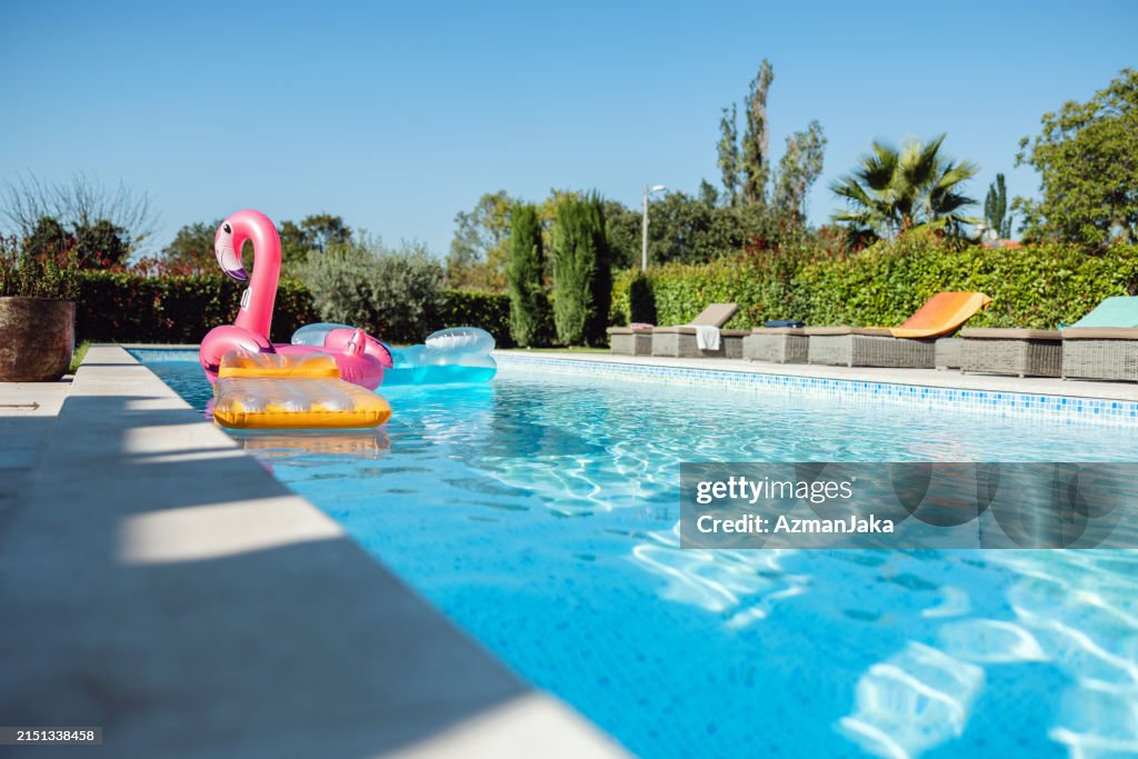 Various Pool Floats Floating In An Empty Pool