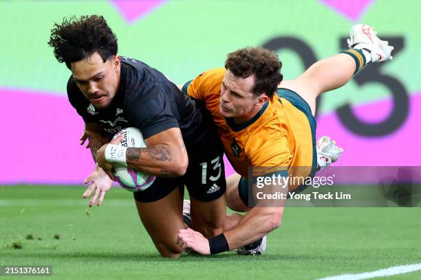 Moses Leo of New Zealand scores a try against Henry Palmer of Australia in the men's pool A match during day two of the HSBC SVNS Singapore at the...