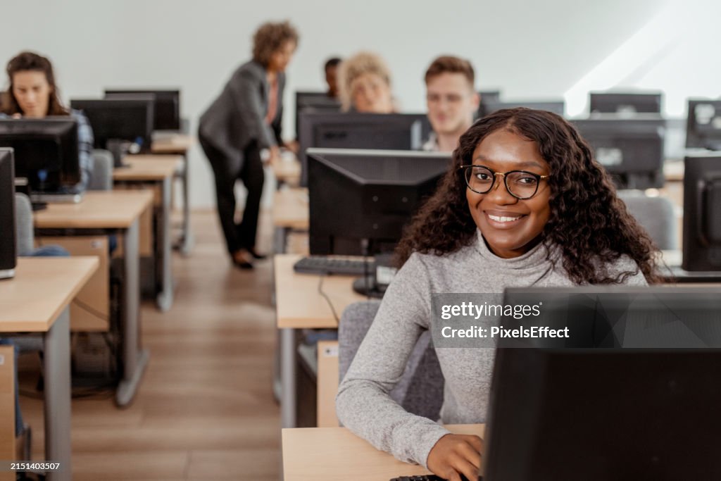 Black Female College Student Looking At Camera During Computer Class ...