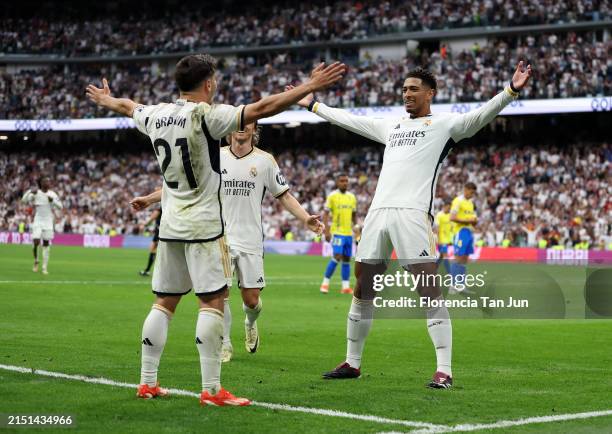 Jude Bellingham of Real Madrid celebrates scoring his team's second goal with teammates Brahim Diaz and Luka Modric during the LaLiga EA Sports match...