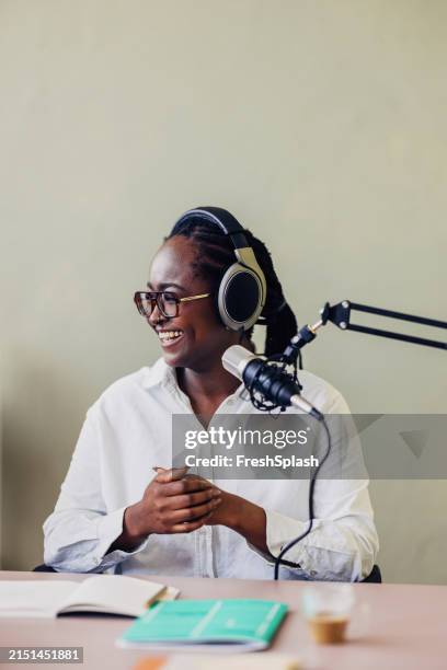 glückliche afroamerikanerin moderiert podcast im studio - moderatorin stock-fotos und bilder
