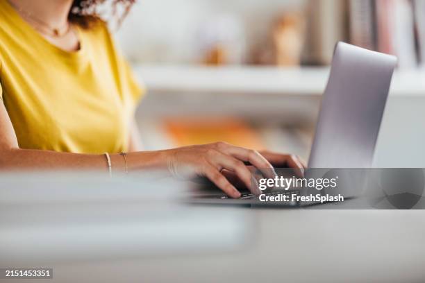 junge frau arbeitet in hellem raum intensiv am laptop - oberteil stock-fotos und bilder