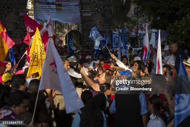 Xochitl Galvez, Mexico's opposition presidential candidate, center, takes photos with attendees at a rally in the Iztacalaco borough of Mexico City,...