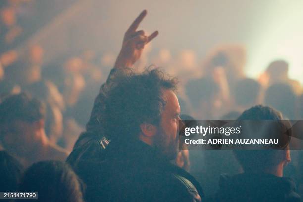 Bearded man in the audience at a metal live concert making the sign of the horns, index and little fingers raised, at the hellfest warm-up tour 2024...