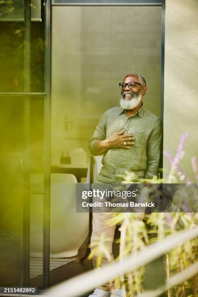 wide shot laughing senior man standing on deck of luxury hotel suite - rooftop deck stock pictures, royalty-free photos & images
