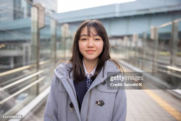 porträt eines teenager-mädchens, das nach der schule in der stadt spazieren geht - nur japaner stock-fotos und bilder