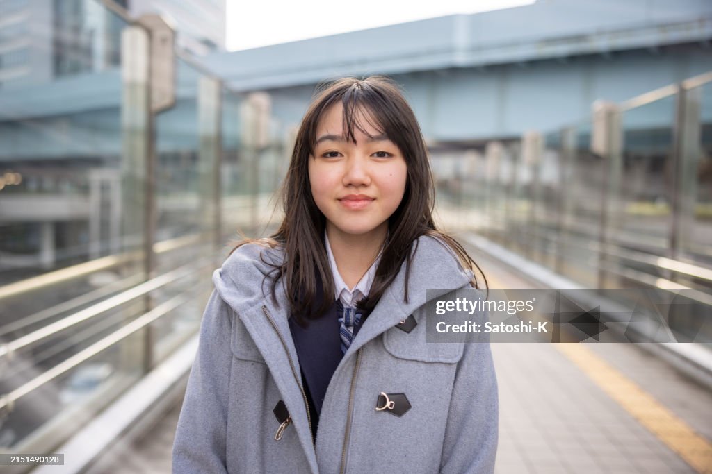 Portrait of teenage girl walking in city after school