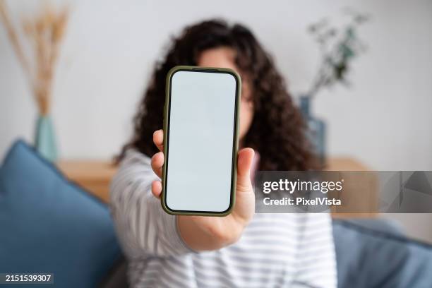 woman presenting smartphone with blank screen - tonen stockfoto's en -beelden